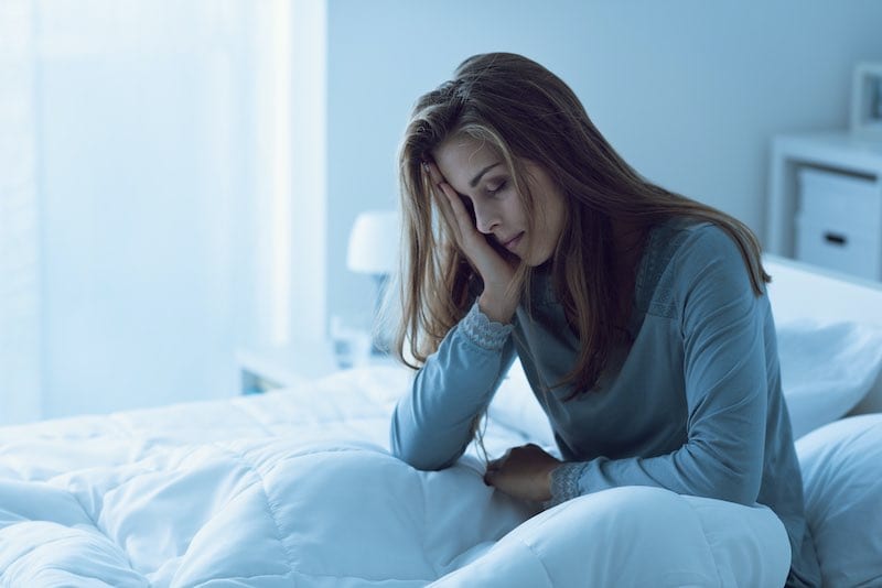 Woman awake in bed dealing with insomnia