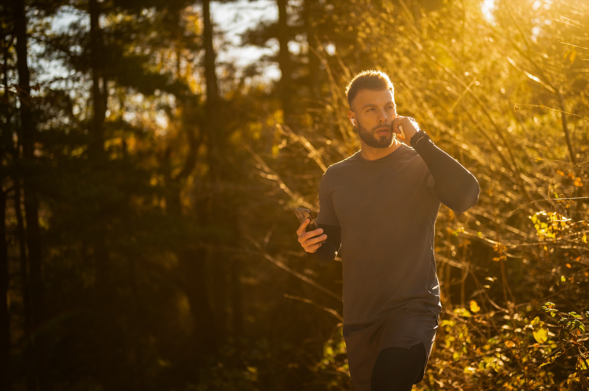 A man running outdoors in autumn morning light